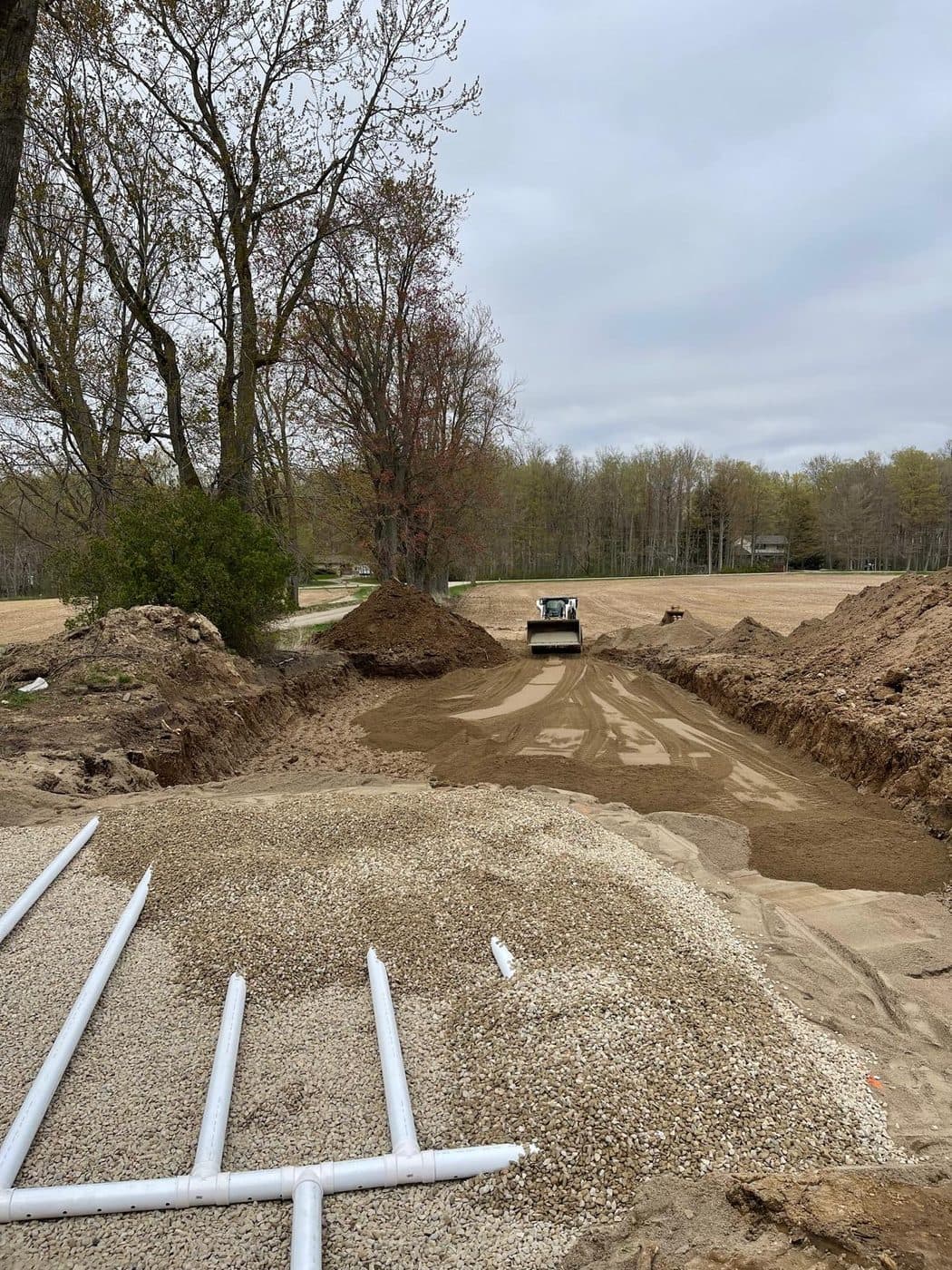 Skid-steer moving sand and fill during a Slegh Septics septic installation